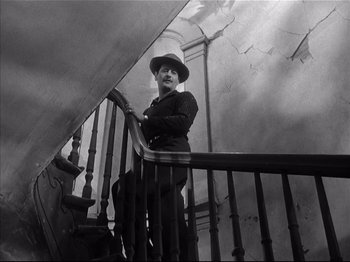 Movie still from “Baby Doll” (1956), directed by Elia Kazan – An old man standing on the stairs of an old building; Wide shot, Low angle