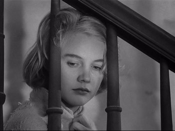 Movie still from “Baby Doll” (1956), directed by Elia Kazan – A young woman leaning on a railing looking sad; Close Up shot, Low angle