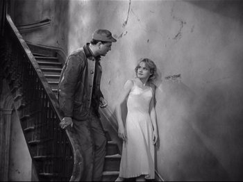 Movie still from “Baby Doll” (1956), directed by Elia Kazan – A man and a woman standing next to each other on stairs; Wide shot, High angle