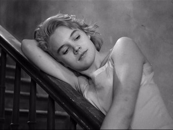 Movie still from “Baby Doll” (1956), directed by Elia Kazan – A young woman sleeping on top of a wooden railing; Close Up shot, High angle