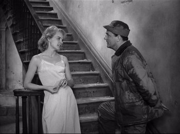 Movie still from “Baby Doll” (1956), directed by Elia Kazan – A man and a woman talking on the stairs of a house; Medium shot, High angle