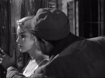 Movie still from “Baby Doll” (1956), directed by Elia Kazan – A man and a woman sitting next to each other in front of a wooden wall; Close Up shot, Over the shoulder angle