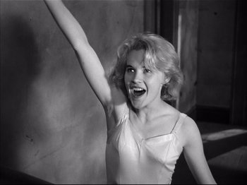 Movie still from “Baby Doll” (1956), directed by Elia Kazan – A young woman is holding her arm up in the air; Medium shot, Low angle