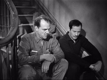 Movie still from “Baby Doll” (1956), directed by Elia Kazan – Two men sitting next to each other on stairs; Medium shot, High angle