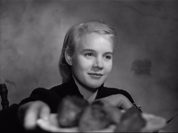 Movie still from “Baby Doll” (1956), directed by Elia Kazan – A young woman sitting in front of a plate of food; Close Up shot, Low angle