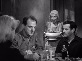 Movie still from “Baby Doll” (1956), directed by Elia Kazan – An old photo of people sitting at a table; Medium shot, Over the shoulder angle