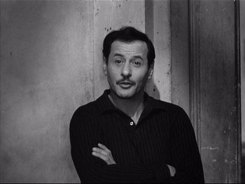 Movie still from “Baby Doll” (1956), directed by Elia Kazan – A black and white photo of a man with his arms crossed; Close Up shot, Low angle