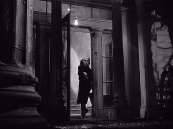 Movie still from “Baby Doll” (1956), directed by Elia Kazan – A woman walking down the stairs of an old building; Wide shot, Low angle