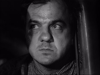 Movie still from “Baby Doll” (1956), directed by Elia Kazan – Black and white photograph of a man's face with bruises; Close Up shot, Low angle