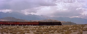 Movie still from “Bad Day at Black Rock” (1955), directed by John Sturges – A train traveling down tracks through a field; Extreme Wide shot, Low angle