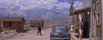 Movie still from “Bad Day at Black Rock” (1955), directed by John Sturges – An old car parked in front of a mountain range; Extreme Wide shot, Low angle