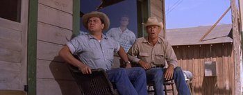 Movie still from “Bad Day at Black Rock” (1955), directed by John Sturges – Two men in cowboy hats sitting on a porch; Medium shot, Low angle