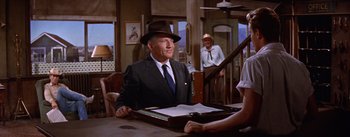 Movie still from “Bad Day at Black Rock” (1955), directed by John Sturges – An older man wearing a suit and hat; Medium shot, Over the shoulder angle
