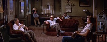 Movie still from “Bad Day at Black Rock” (1955), directed by John Sturges – A group of men sitting on a couch in a living room; Wide shot, High angle