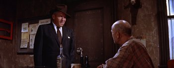 Movie still from “Bad Day at Black Rock” (1955), directed by John Sturges – A man in a suit and hat talking to another man in a hat; Medium shot, Low angle