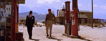 Movie still from “Bad Day at Black Rock” (1955), directed by John Sturges – A man standing on the side of a road near a fire hydrant; Wide shot, Low angle