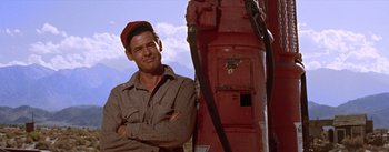 Movie still from “Bad Day at Black Rock” (1955), directed by John Sturges – A man standing next to a red fire hydrant; Medium shot, Low angle