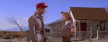 Movie still from “Bad Day at Black Rock” (1955), directed by John Sturges – A man and a woman standing next to each other in front of a house; Medium shot, Low angle