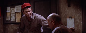 Movie still from “Bad Day at Black Rock” (1955), directed by John Sturges – A man in a red hat is talking to another man in a red hat; Medium shot, Over the shoulder angle