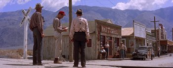 Movie still from “Bad Day at Black Rock” (1955), directed by John Sturges – A group of men standing next to each other on a street; Wide shot, Low angle