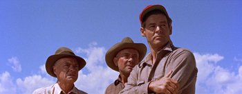 Movie still from “Bad Day at Black Rock” (1955), directed by John Sturges – A group of men standing next to each other on top of a hill; Medium shot, Low angle
