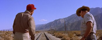 Movie still from “Bad Day at Black Rock” (1955), directed by John Sturges – A man standing on a train track in the middle of nowhere; Wide shot, Low angle