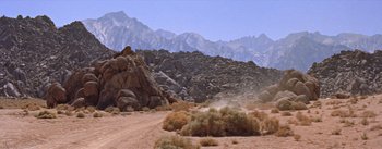 Movie still from “Bad Day at Black Rock” (1955), directed by John Sturges – A dirt road in front of a mountain range; Extreme Wide shot, High angle