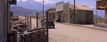 Movie still from “Bad Day at Black Rock” (1955), directed by John Sturges – An old jeep driving down a dirt road in the middle of the desert; Extreme Wide shot, High angle