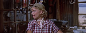 Movie still from “Bad Day at Black Rock” (1955), directed by John Sturges – A woman in a plaid shirt and a hat; Close Up shot, Over the shoulder angle