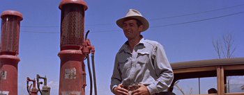 Movie still from “Bad Day at Black Rock” (1955), directed by John Sturges – A man wearing a cowboy hat standing next to a fire hydrant; Medium shot, Low angle