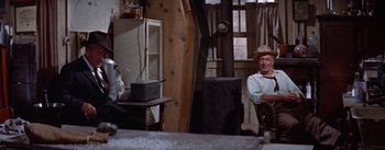 Movie still from “Bad Day at Black Rock” (1955), directed by John Sturges – An older man sitting in a chair in a room; Medium shot, High angle