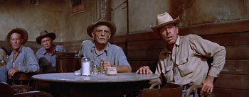Movie still from “Bad Day at Black Rock” (1955), directed by John Sturges – Two men sitting at a table in front of drinks; Medium shot, Low angle