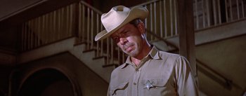 Movie still from “Bad Day at Black Rock” (1955), directed by John Sturges – A man wearing a cowboy hat standing in front of a staircase; Close Up shot, Low angle
