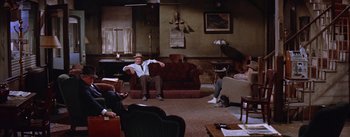 Movie still from “Bad Day at Black Rock” (1955), directed by John Sturges – A man sitting on top of a couch in a living room; Wide shot, High angle