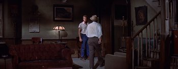 Movie still from “Bad Day at Black Rock” (1955), directed by John Sturges – Two men standing in a living room talking to each other; Wide shot, Over the shoulder angle