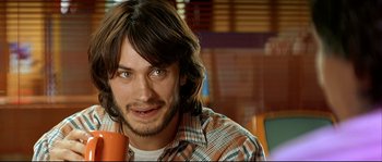 Movie still from “Bad Education” (2004), directed by Pedro Almodóvar – A person holding a drink in a room; Close Up shot, High angle