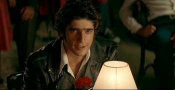 Movie still from “Bad Education” (2004), directed by Pedro Almodóvar – A young man sitting in front of a table lamp; Close Up shot, Over the shoulder angle