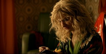 Movie still from “Bad Education” (2004), directed by Pedro Almodóvar – A woman with long blonde curly hair looking down at a piece of paper; Close Up shot, Over the shoulder angle