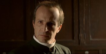 Movie still from “Bad Education” (2004), directed by Pedro Almodóvar – A person wearing a priest's outfit; Close Up shot, Low angle