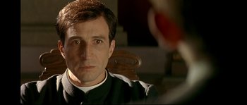 Movie still from “Bad Education” (2004), directed by Pedro Almodóvar – A person sitting in a chair; Close Up shot, Over the shoulder angle