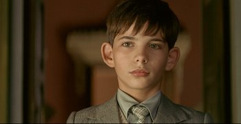 Movie still from “Bad Education” (2004), directed by Pedro Almodóvar – A young boy in a suit and a tie; Close Up shot, Over the shoulder angle