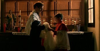 Movie still from “Bad Education” (2004), directed by Pedro Almodóvar – A man and a boy are holding a dress; Medium shot, Over the shoulder angle
