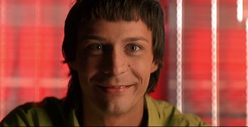 Movie still from “Bad Education” (2004), directed by Pedro Almodóvar – A person smiling for the camera; Close Up shot, Low angle