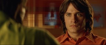 Movie still from “Bad Education” (2004), directed by Pedro Almodóvar – A person wearing a red shirt; Close Up shot, Over the shoulder angle