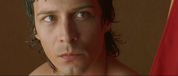 Movie still from “Bad Education” (2004), directed by Pedro Almodóvar – A man's face with long black hair; Extreme Close Up shot, Low angle