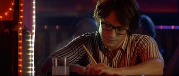Movie still from “Bad Education” (2004), directed by Pedro Almodóvar – A man with glasses writing on a piece of paper; Close Up shot, Over the shoulder angle