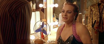 Movie still from “Bad Education” (2004), directed by Pedro Almodóvar – A woman sitting in front of a mirror in front of a fan; Close Up shot, Over the shoulder angle
