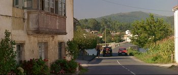 Movie still from “Bad Education” (2004), directed by Pedro Almodóvar – A street scene with cars parked on the side of the road; Extreme Wide shot, High angle