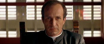 Movie still from “Bad Education” (2004), directed by Pedro Almodóvar – A person wearing a priest's outfit; Close Up shot, Low angle