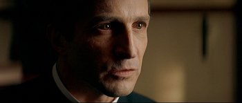 Movie still from “Bad Education” (2004), directed by Pedro Almodóvar – A man's face in a dark room; Close Up shot, Over the shoulder angle